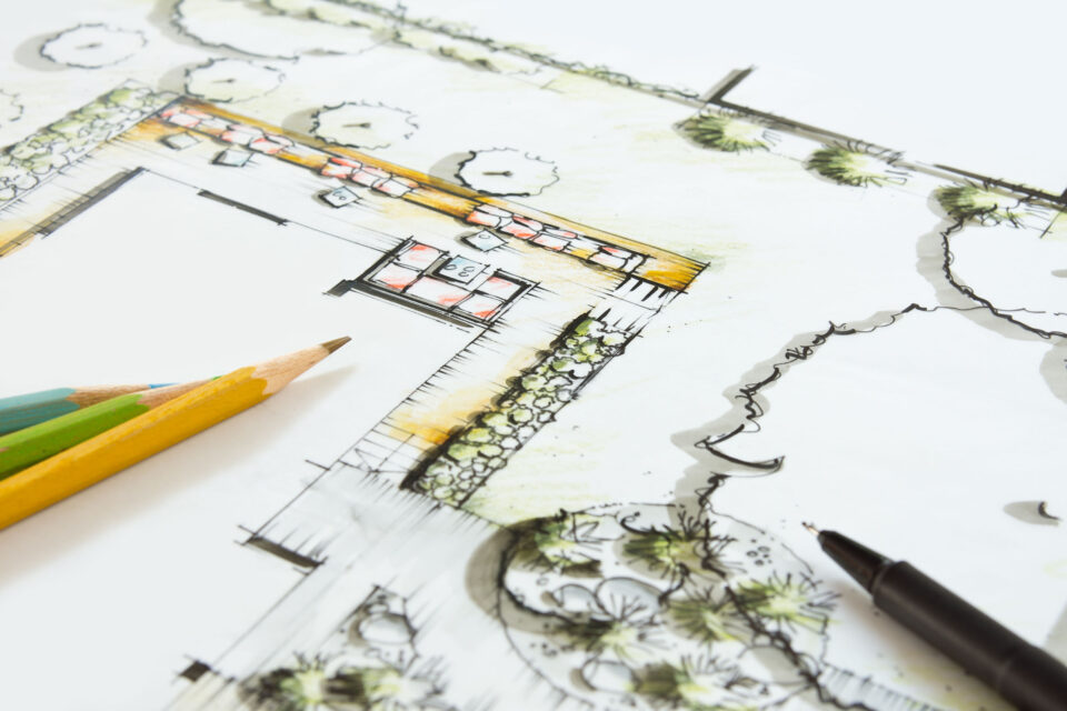 Landschaftsarchitektur - Entwurf für einen privaten Garten. Buntstifte und Stift liegen auf dem Plan.